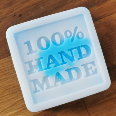 błękitno-białe mydełko z napisem 100% hand made